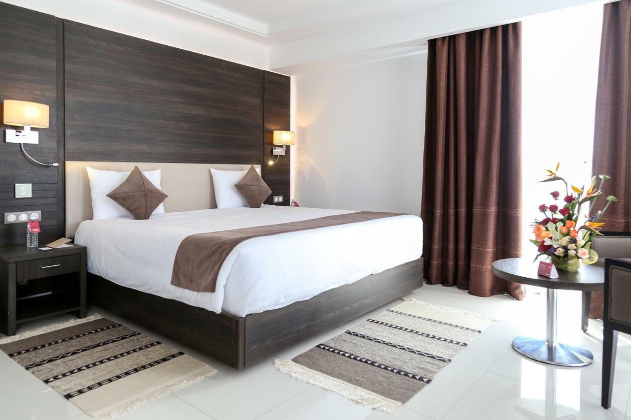 Radisson Hotel Szfaksz Kültér fotó A bedroom in a hotel